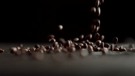 coffee beans fall in slow motion on a table with black background - 120fps