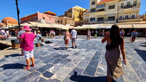 beautiful tourist woman walks on the esplanade of the camellon square on the coast of chania in crete greece