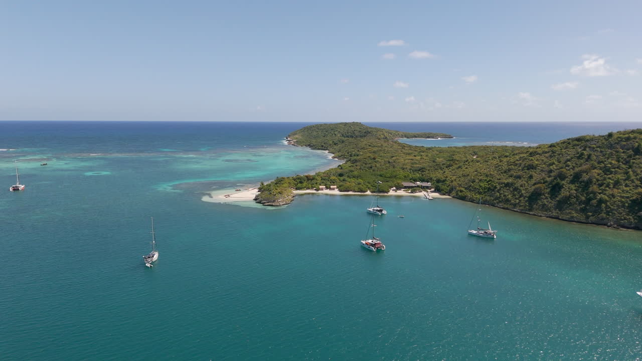 Vista aerea di vivaci acque turchesi e barche ormeggiate vicino a Green Island ad Antigua, paesaggio marino caraibico incontaminato e scenario di isola tropicale