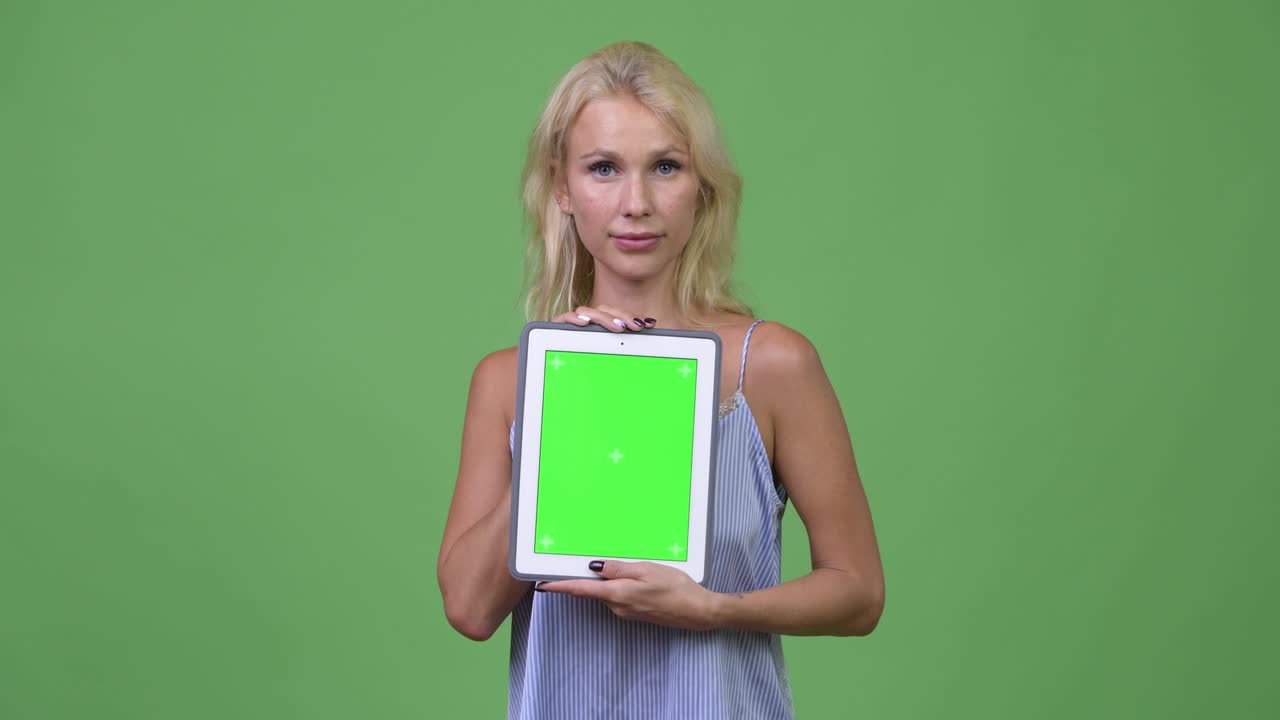 Giovane, felice e bellissima donna d'affari che mostra un tablet.