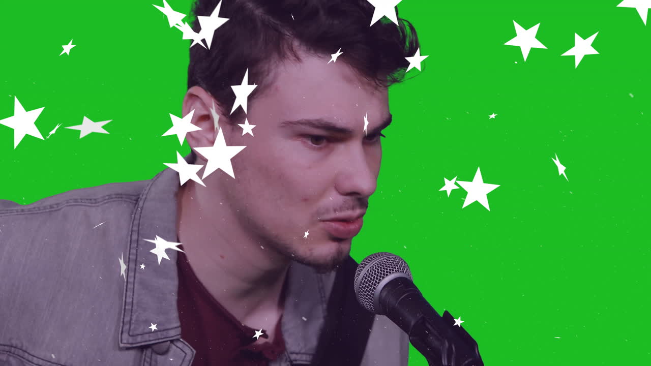 Male singer singing into microphone on green screen for music marketing, overlaying star graphics