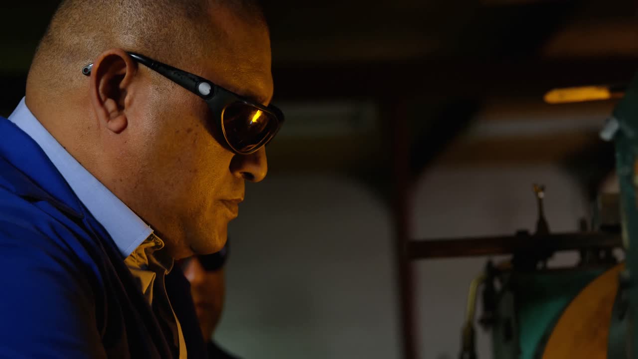 유리 공장에서 유리를 만드는 남성 노동자의 측면 뷰 4k