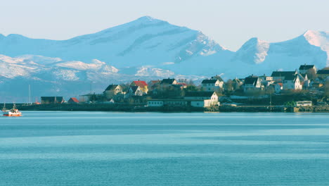 Cinematic-shot-of-a-fishing-boat-arriving-home-to-a-town-in-the-Lofoten-Islands