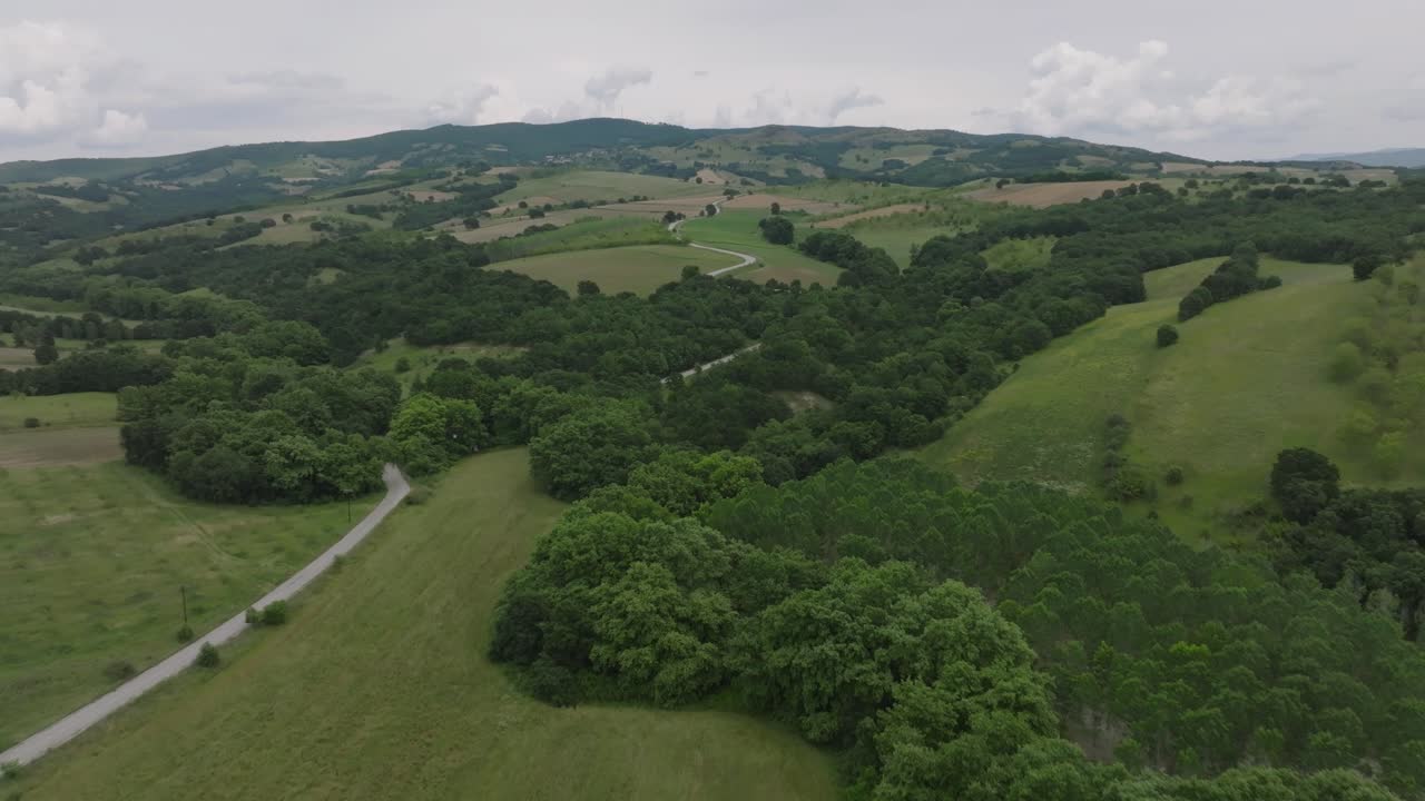 camino de campo que serpentea por la exuberante ladera de la montaña en el campo griego, tesalia