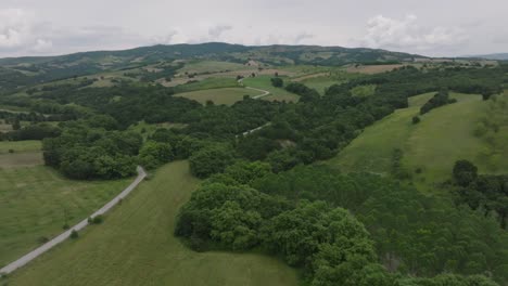 Carretera-Rural-Que-Serpentea-Por-La-Exuberante-Ladera-De-La-Montaña-En-La-Campiña-Griega,-Tesalia