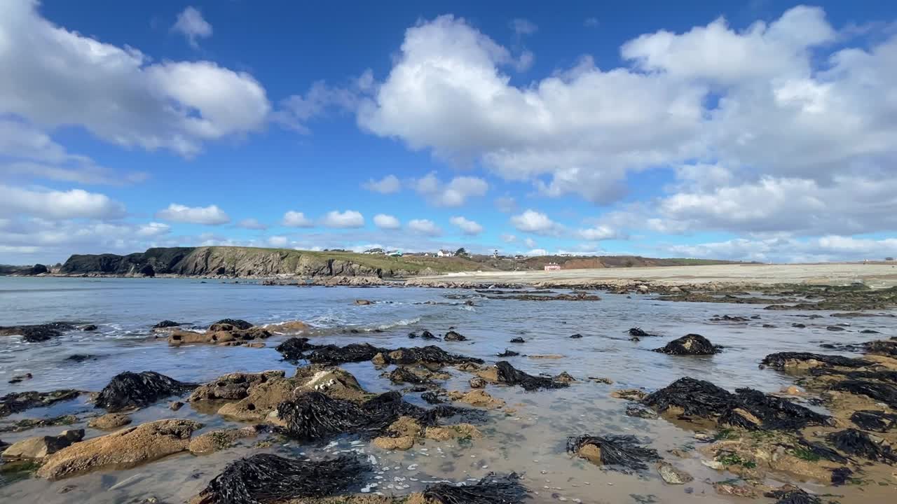 Ireland Epic Locations gentle waves incoming on rocky beach on a bright day Annestown Copper Coast Waterford