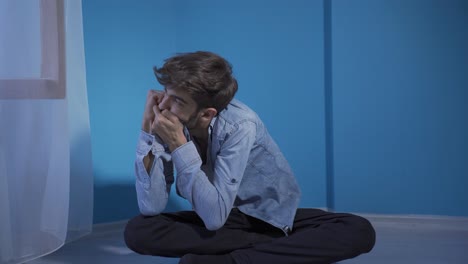 man having a nervous breakdown by the wall.