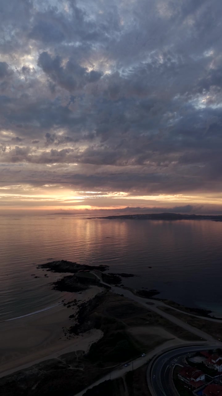 Vertikalt luftfoto ved solnedgang over Ermita de la Lanzada-halvøen og Atlanterhavskysten i Galicien, Spanien