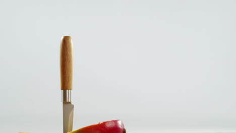 halved mango and knife on wooden table