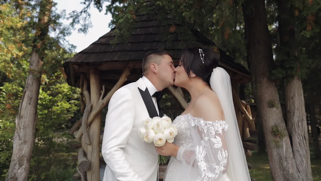 Novomanželé, kavkazský ženich s nevěstou se procházejí, objímají se v parku, zamilovaný svatební pár.
