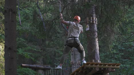 the man is carefully climbing onto the wooden