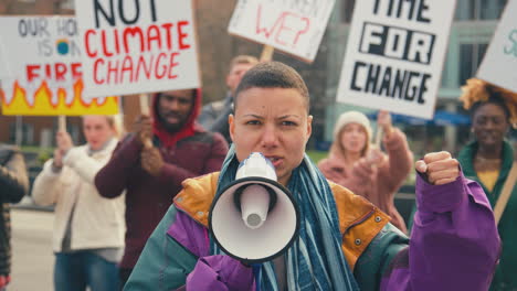 group of protestors with placards and megaphone on demonstration march against climate change