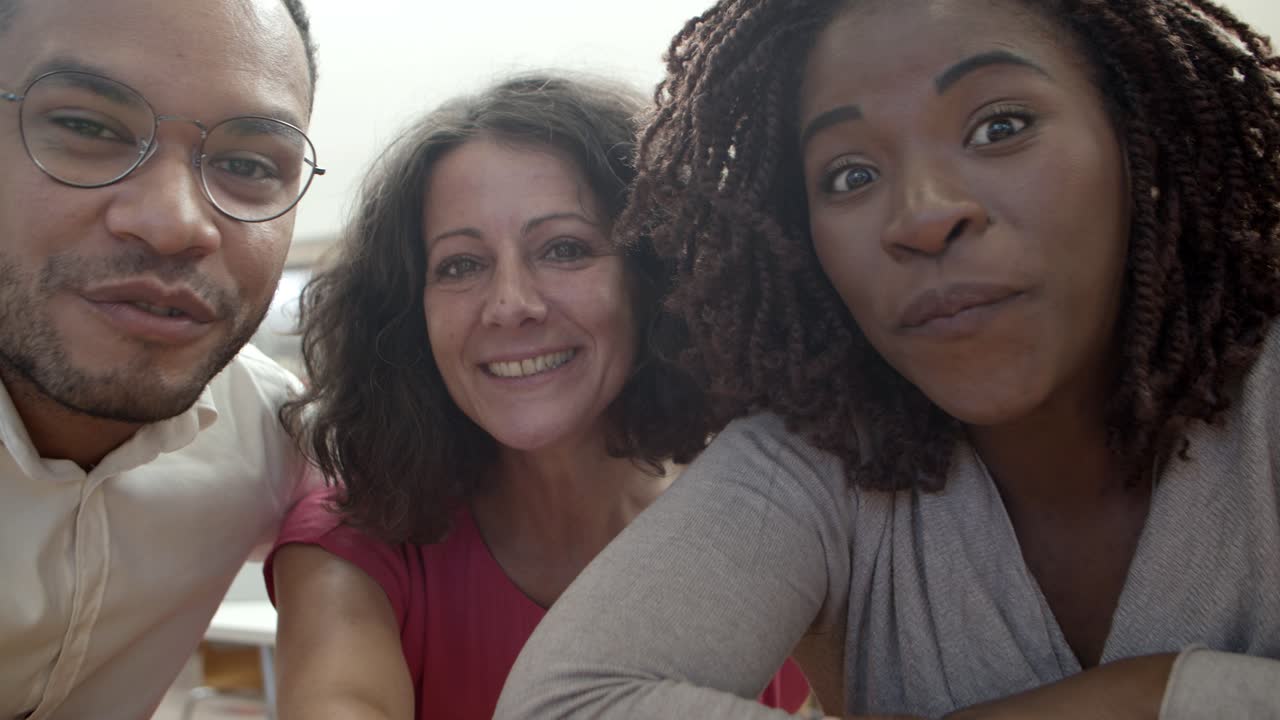 веселые люди улыбаются и разговаривают во время видеозвонка кому-то в библиотеке