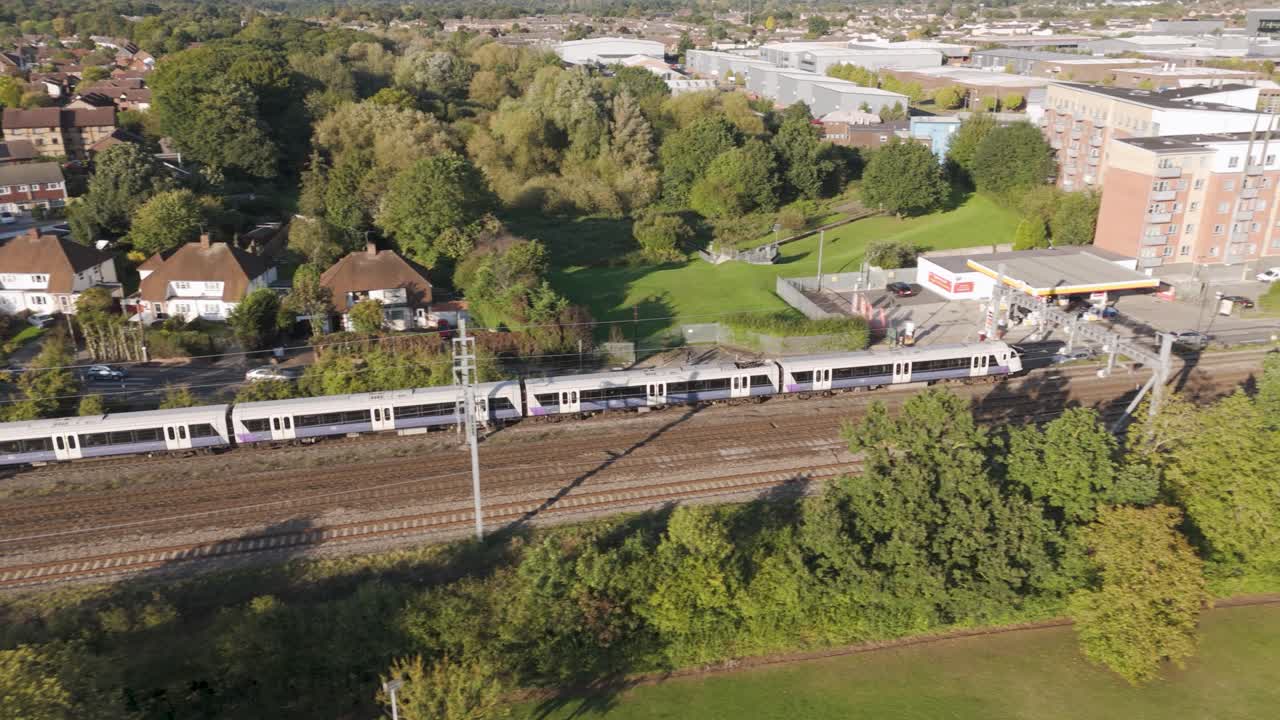Parallel trains on railway tracks surrounded by suburban greenery heading towards London Paddington through Slough, Berkshire, UK, October 2024