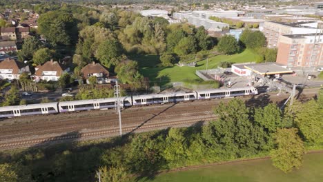 parallel trains on railway tracks surrounded by suburban greenery heading towards london paddington through slough, berkshire, uk, october 2024