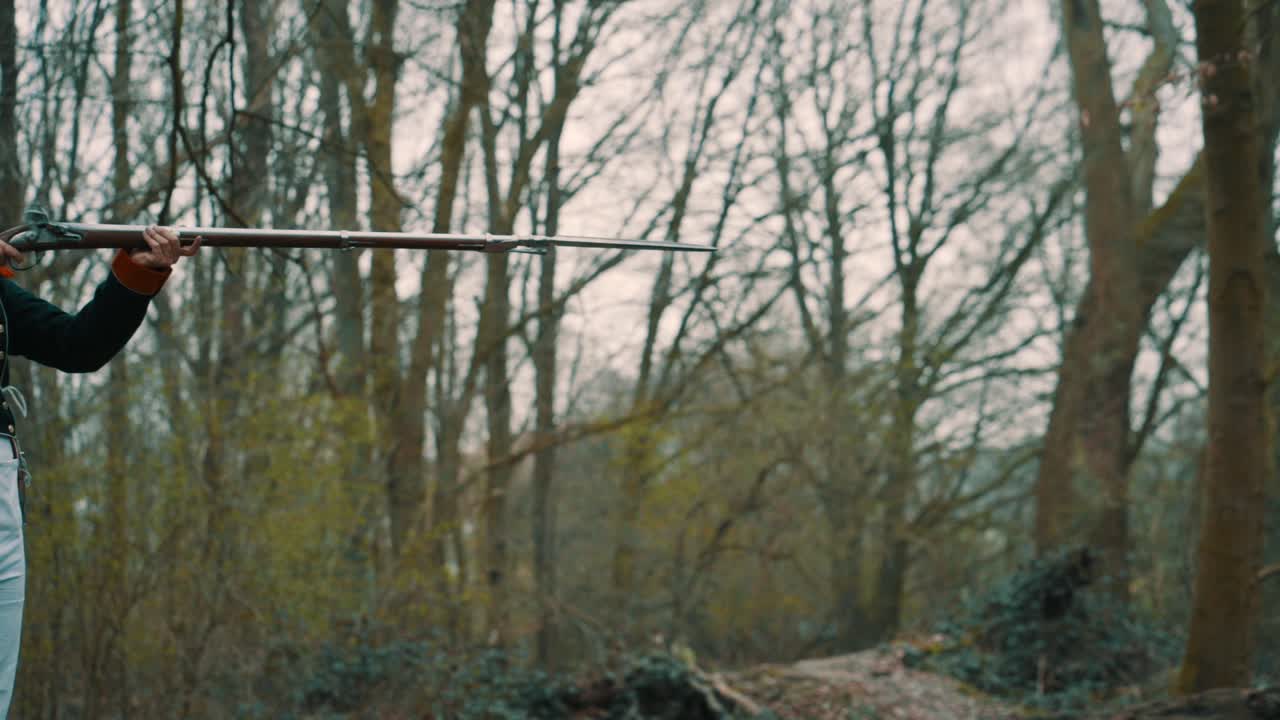 Profile gunshot in the woods of a soldier with a historical weapon and smoke in slow motion.