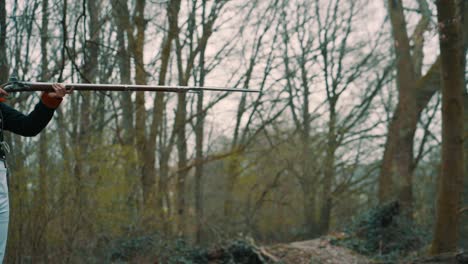 profile gunshot in the woods of a soldier with a historical weapon and smoke in slow motion.