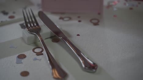 elegante cuchillo y tenedor en un evento sobre un mantel blanco con anillos decorativos