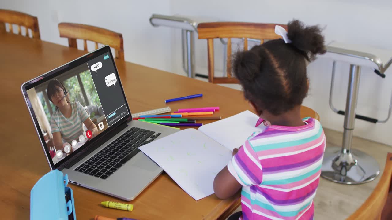 Schoolgirl using laptop for online lesson at home, with female teacher and web chat on screen
