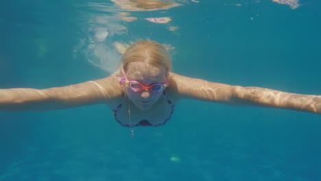 a woman is swimming in the pool underwater slowmotion video