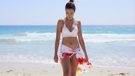 young woman in a bikini standing on a beach
