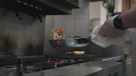 chef volteando salchichas en una sartén