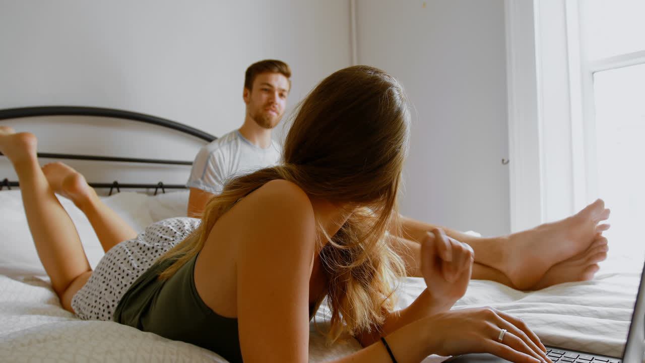 Woman using laptop on bed in bedroom 4k