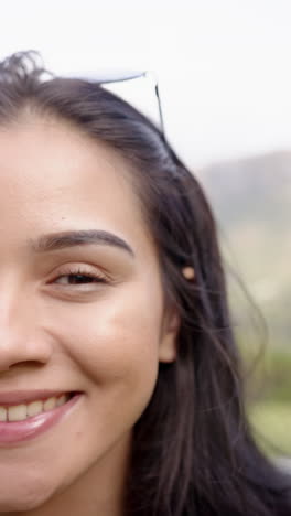 vertical video: enjoying outdoor setting, smiling woman with sunglasses on head
