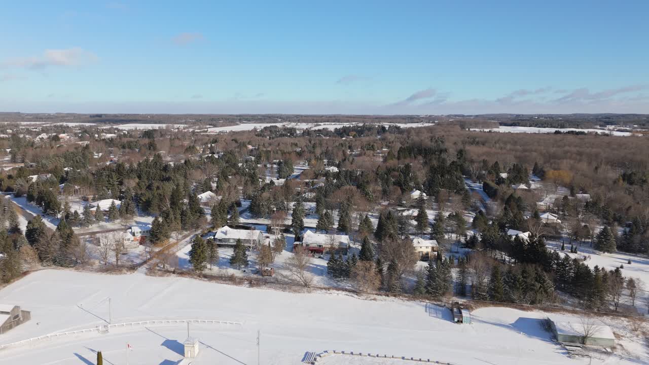 A peaceful snowy neighborhood aerial view in Caledon Village, Ontario, under clear skies