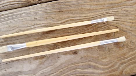 Various-paint-brushes-on-wooden-table