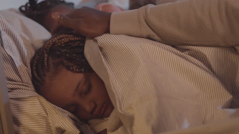 parent covering daughter with blanket