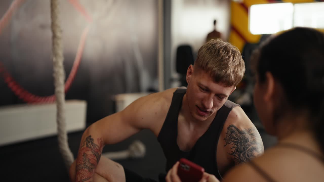 남자 와 여자 가 체육관 에서 대화 하고 있다