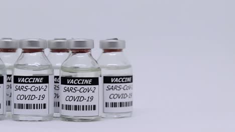 corona virus vaccine in bottle over white background - panning shot