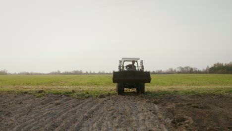 agricultor que maneja un tractor en un campo