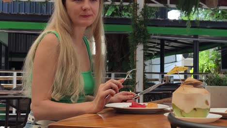 woman eating fresh fruit salad and coconut at a tropical restaurant