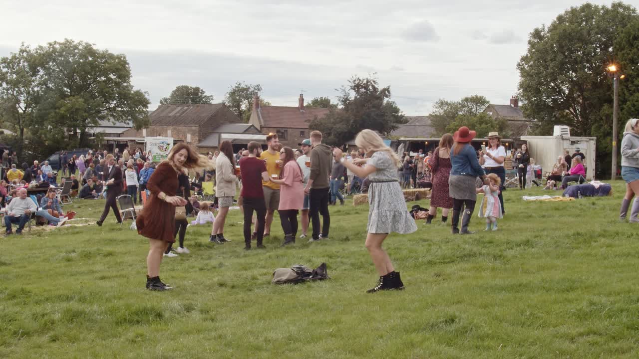 Young caucasian women dance and have fun with friends at Rotherham Farmfest