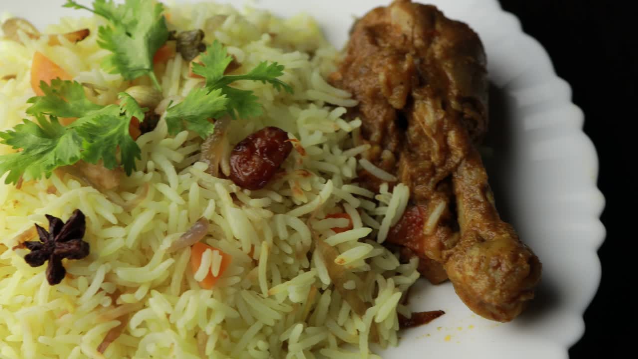 pollo biryani mostrando pedazo de pierna - es una deliciosa receta de arroz basmati mezclado con pollo marinado picante en un tazón. servido en un plato o plato. enfoque selectivo