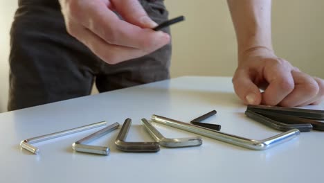 man selecting hex key of multiple hex key tools, close up