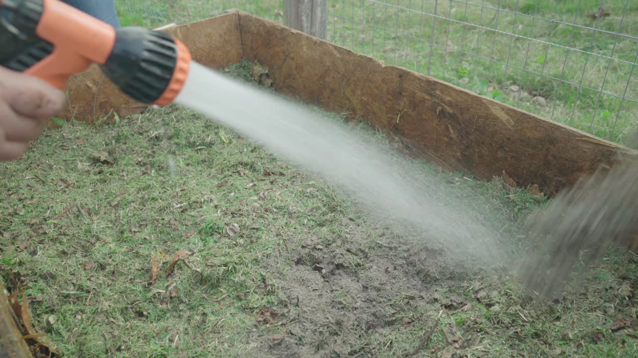 Women prepare a home wooden compost heap box. They add Microorganisms to organic waste.