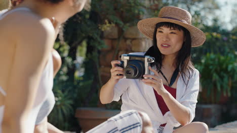 Schöne-Asiatische-Frau,-Die-Ein-Foto-Von-Freunden-Macht,-Die-Sich-Am-Pool-Entspannen-Und-Einen-Sonnigen-Urlaubstag-Genießen.-Mädchen,-Die-Spaß-Daran-Haben,-Vor-Der-Kamera-Zu-Posieren-Und-Sommerurlaubserinnerungen-In-4K-Zu-Machen