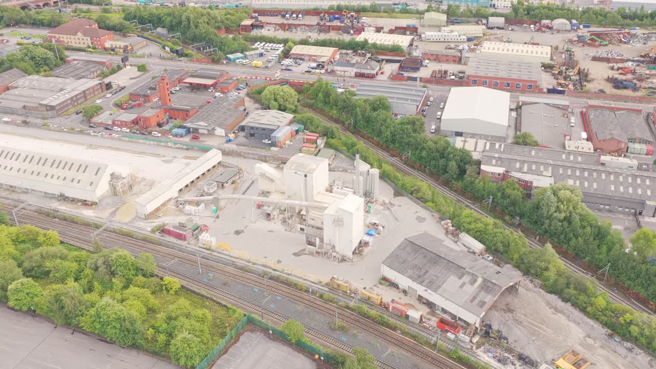 Aerial view of Salford’s industrial zone showing a large cement plant, warehouses, and rail tracks connecting to the wider Greater Manchester freight network