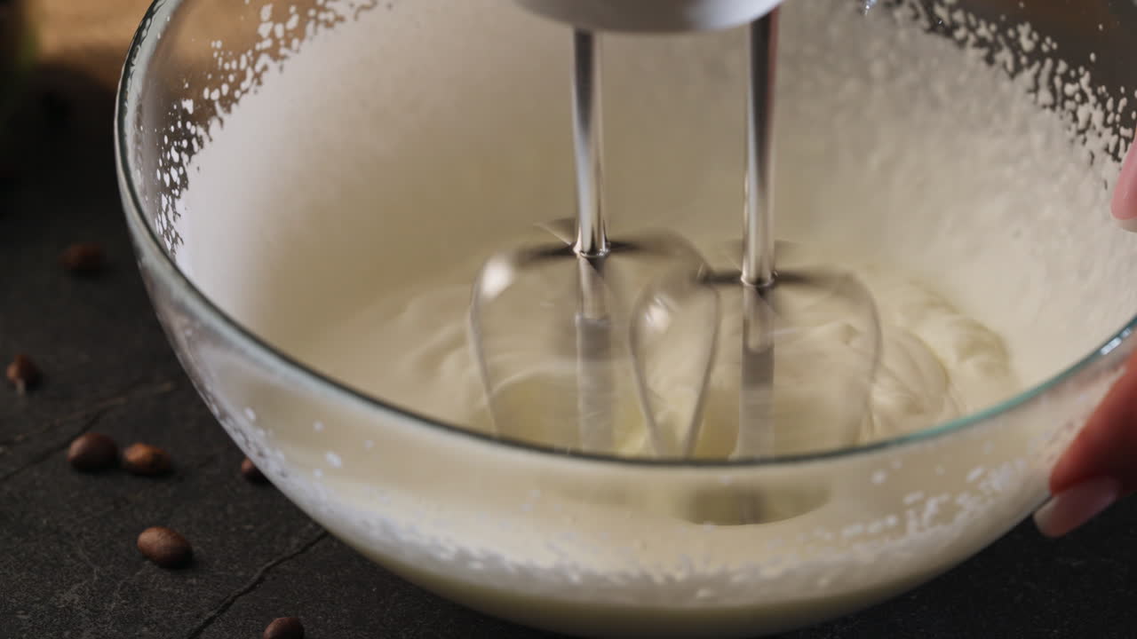 Montare elettricamente un impasto cremoso per tiramisù. Primo piano