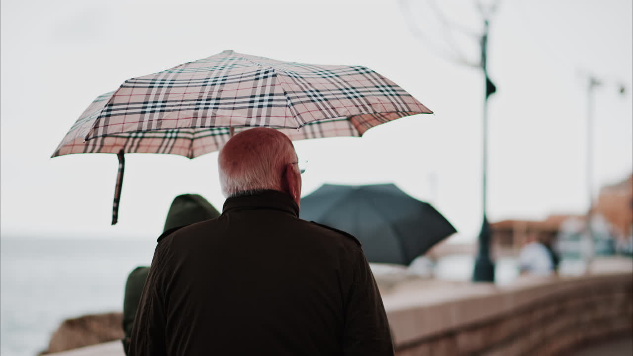 Man walking on the street with an umbrella in Villefranche-sur-Mer, France