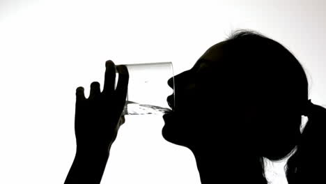 silhouette of woman drinking from glass