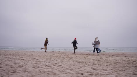 friends having fun on a winter beach