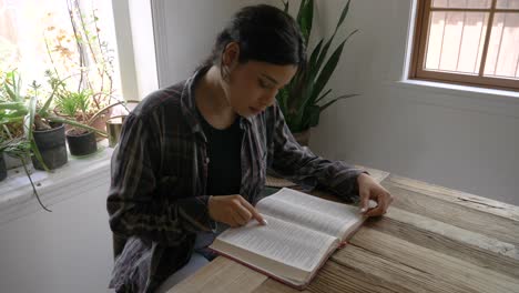 niña puertorriqueña estudiando la biblia leyendo las escrituras en el escritorio en casa