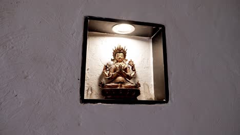 Buddha-Statue,-Beleuchtet-Durch-Einen-Scheinwerfer-In-Einer-Eingelassenen-Wandnische