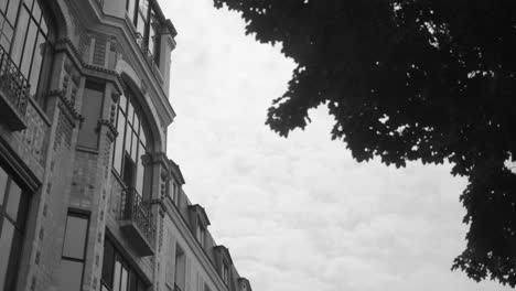exterior of artist studio art deco building in black and white (monochrome). art deco architecture by andre arfvidson in paris, france. low angle, slider left