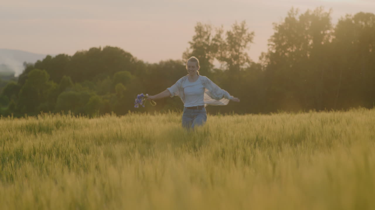 mujer feliz regocijándose y corriendo por los campos al atardecer