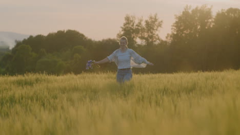 mujer feliz regocijándose y corriendo por los campos al atardecer